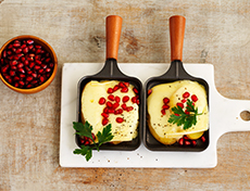 Potatoes with Raclette cheese, coriander and pomegranate seeds