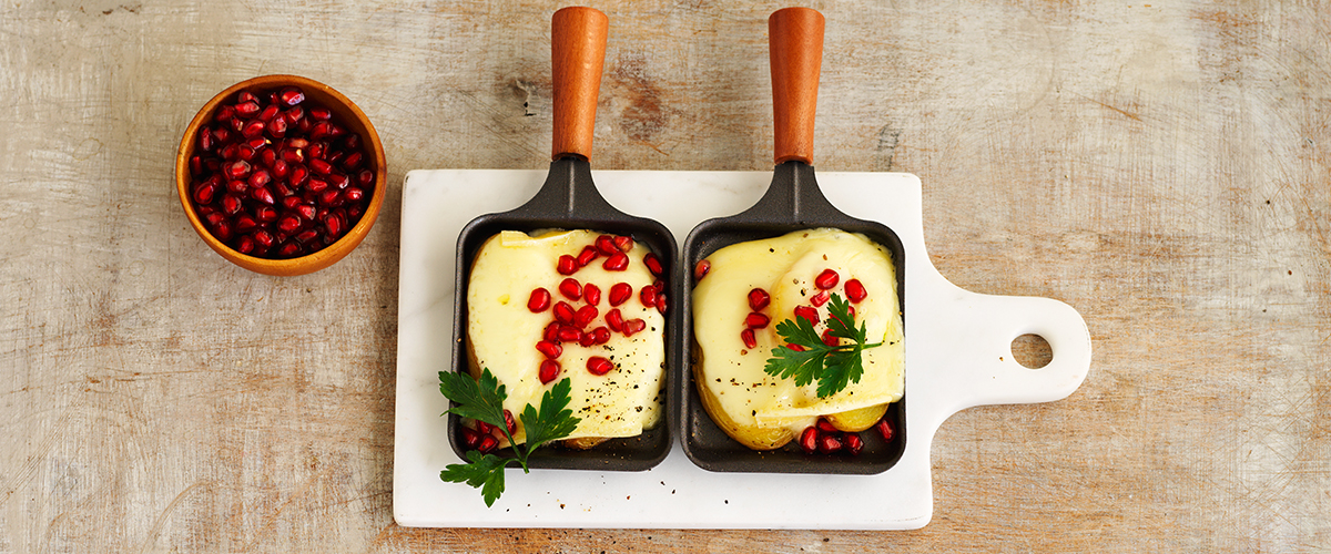 Potatoes with Raclette cheese, coriander and pomegranate seeds